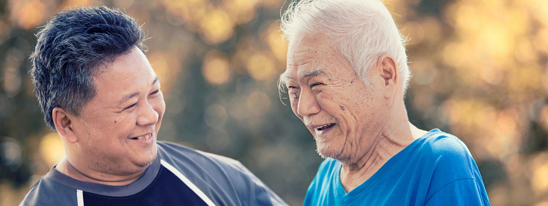 younger man standing with elder man outside