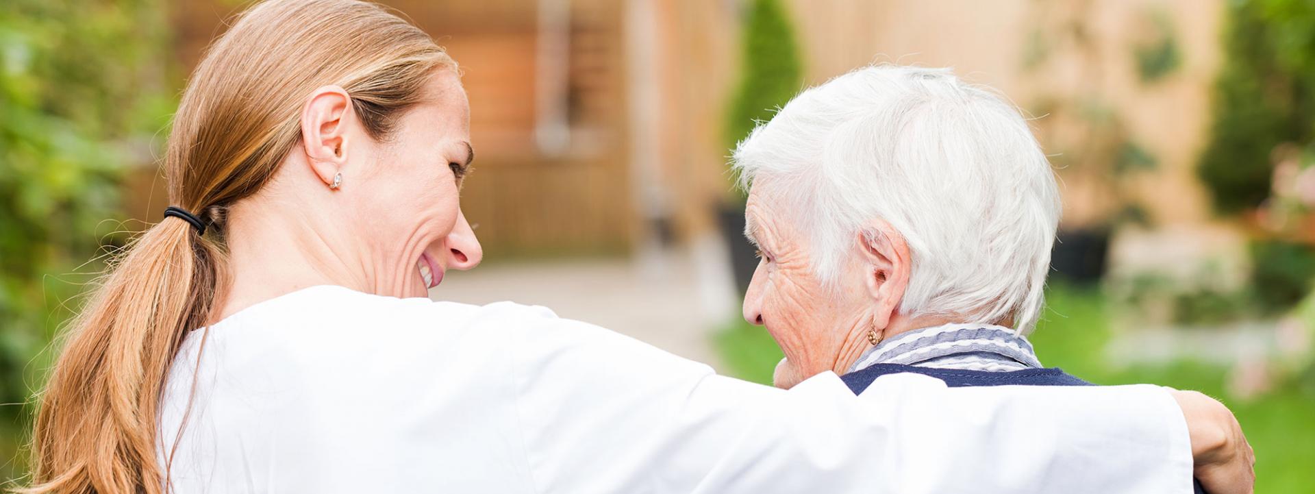 younger woman with arm around older woman